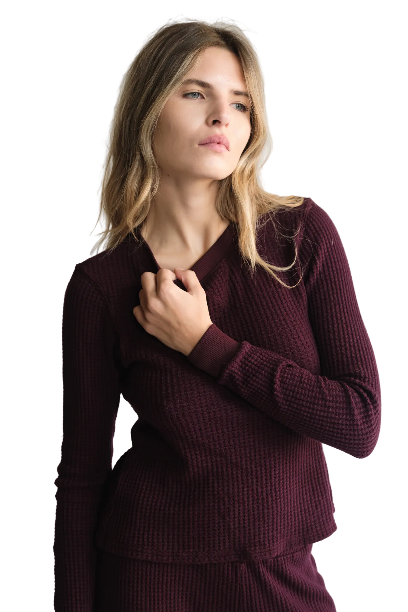 Woman wearing a burgundy sweater against a white background
