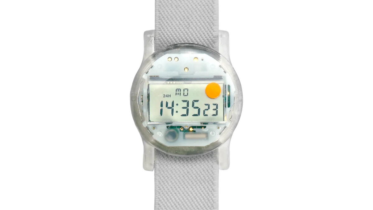 Digital watch with a clear face on a white strap against a white background