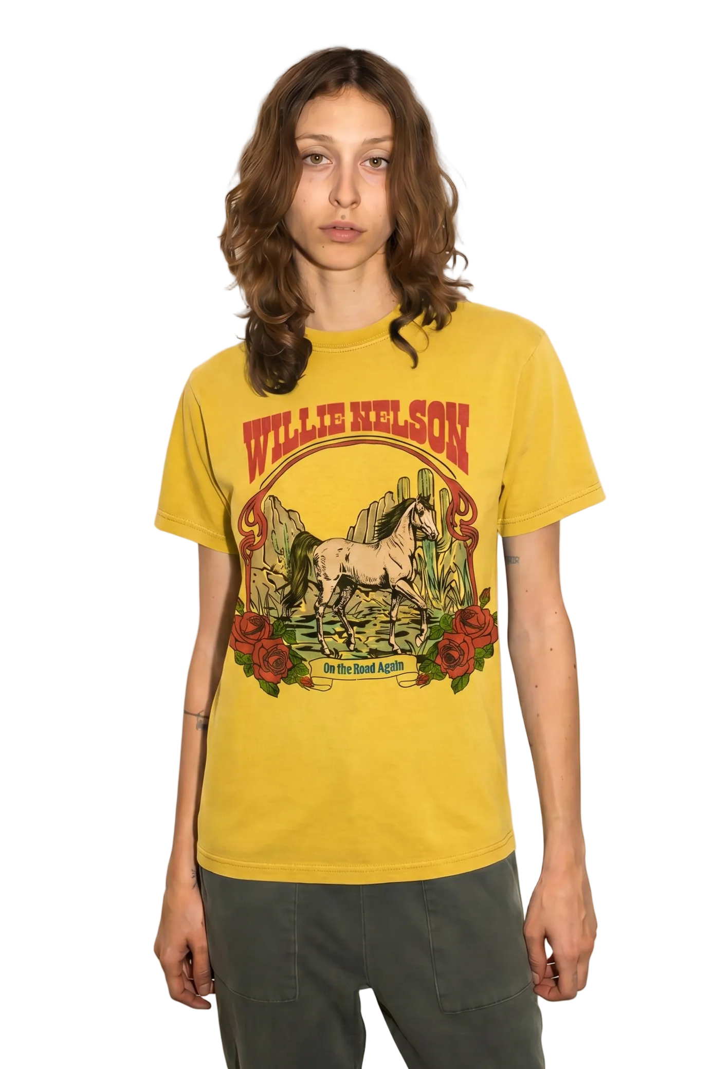 A model wearing a yellow Willie Nelson graphic t-shirt and dark gray pants, standing against a solid beige background.