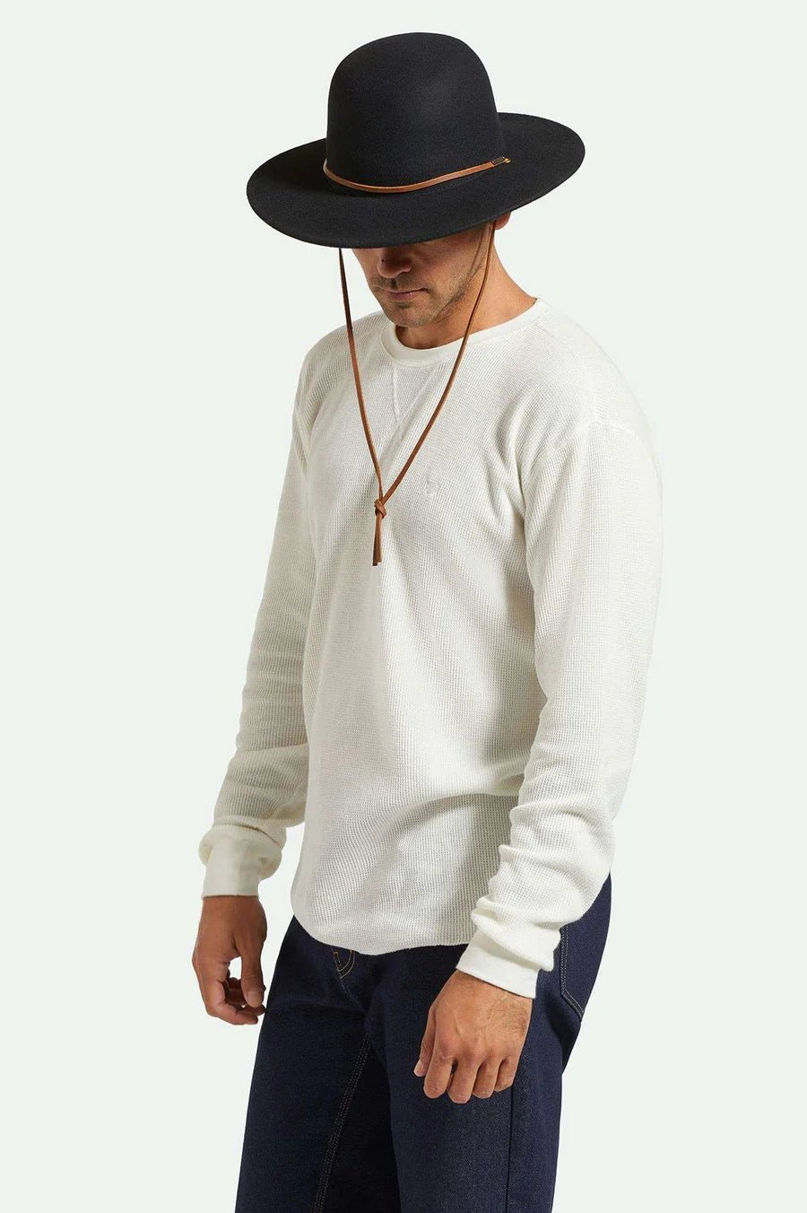 Model wearing Brixton 20th Anniversary Tiller Hat — wide-brim wool felt fedora with adjustable Velcro strap.
