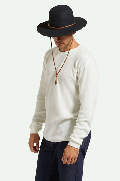 Model wearing Brixton 20th Anniversary Tiller Hat — wide-brim wool felt fedora with adjustable Velcro strap.