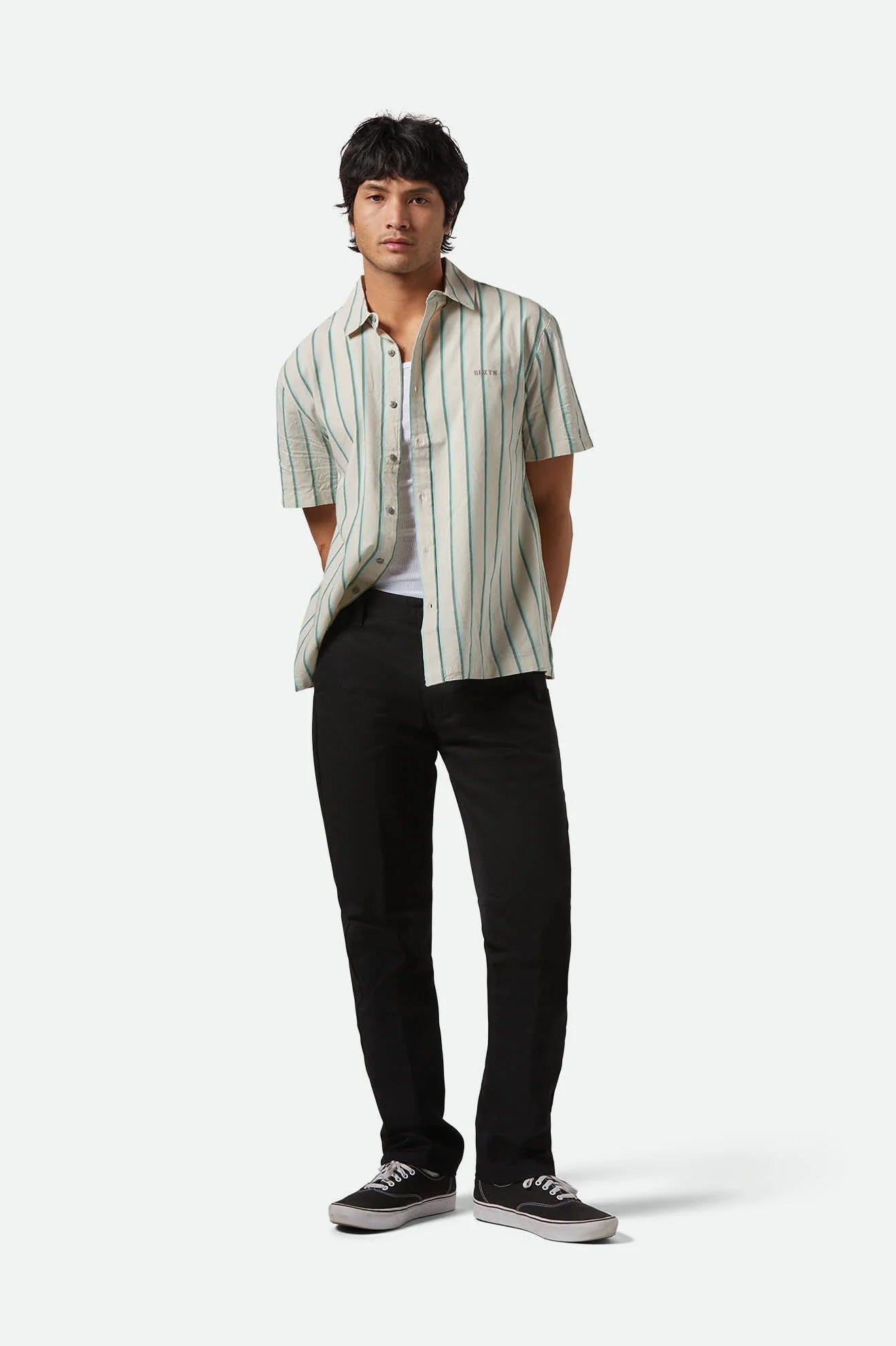 Model wearing Brixton Choice Regular Chinos straight-leg pants in durable stretch twill, medium rise waist.