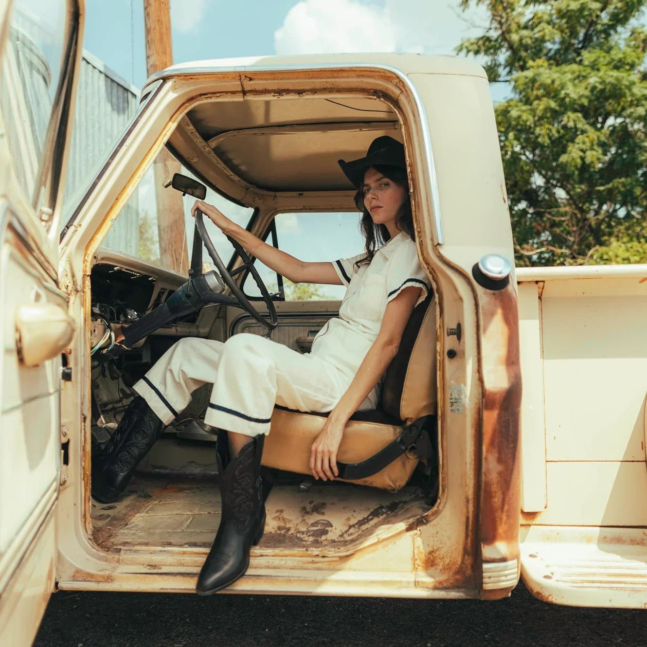 woman wearing the Dolly Jumpsuit in an old truck - Paranoid Ranch