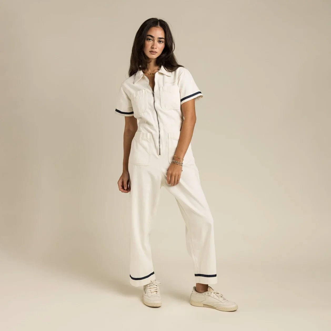 Sendero Dolly Jumpsuit featuring soft cotton fabric, navy tape trims, chest pocket embroidery, and functional zip closure.