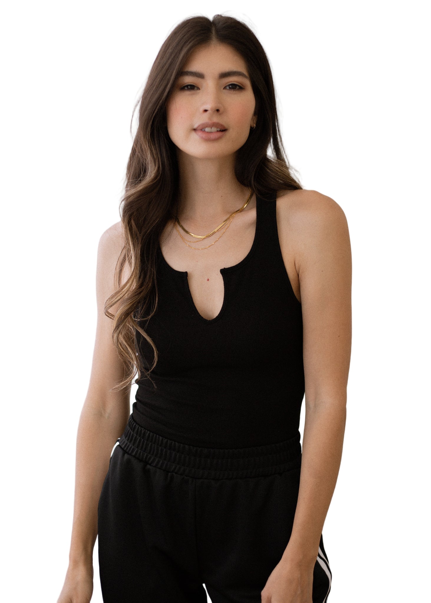 Woman wearing a black sleeveless top with a cutout design against a neutral background