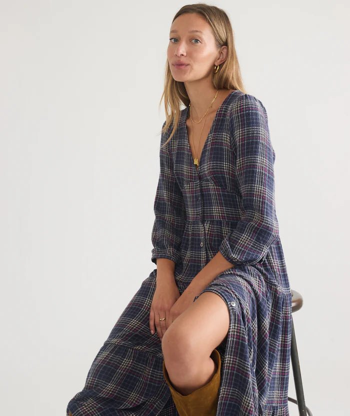 woman sitting on a stoll wearing the plaid marine layer Maeve Maxi Dress - Paranoid Ranch