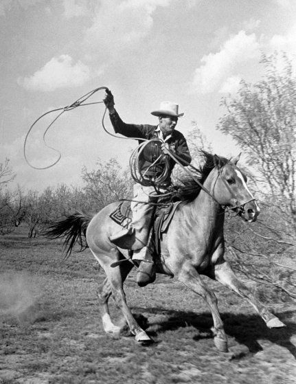 Cowboy on horseback with a lasso against a cloudy sky