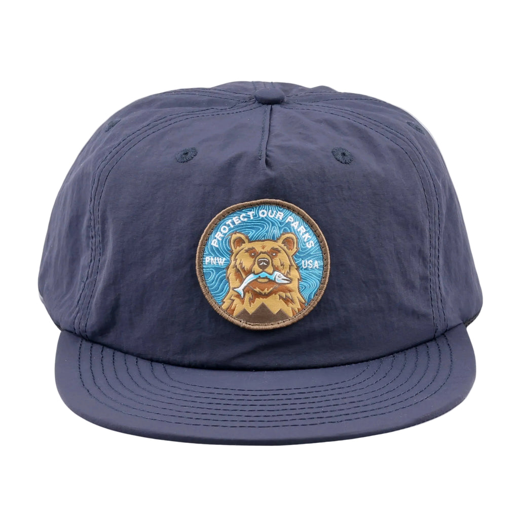 Navy blue cap with a bear patch on a white background