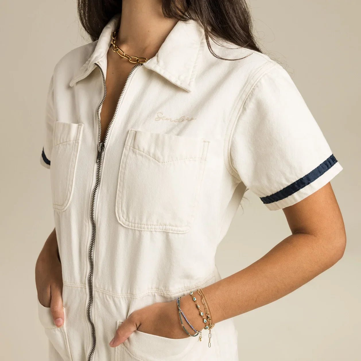 torso image of the Dolly Jumpsuit - close up of the pockets and sendero logo.