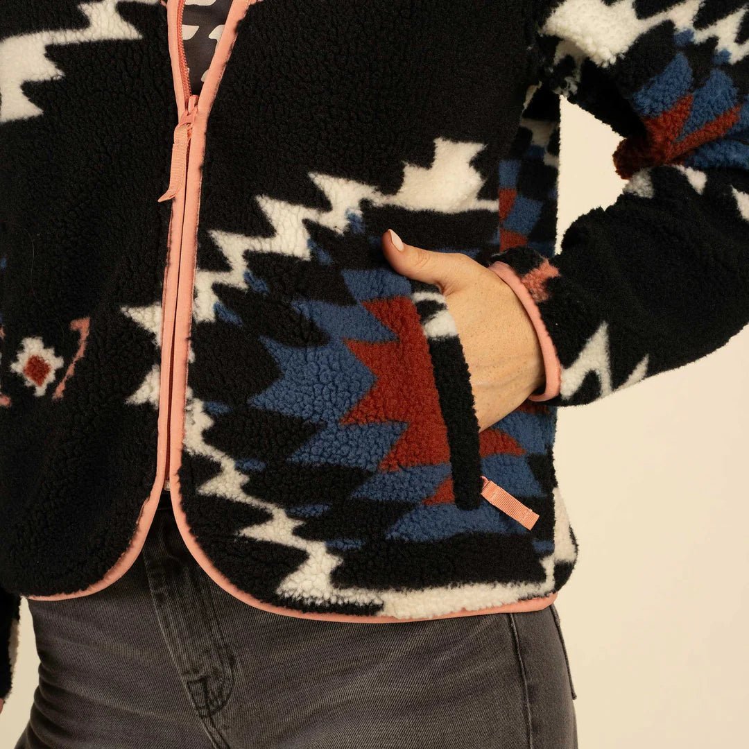 Sendero women’s fleece jacket in bold graphic southwest pattern with coral binding details.