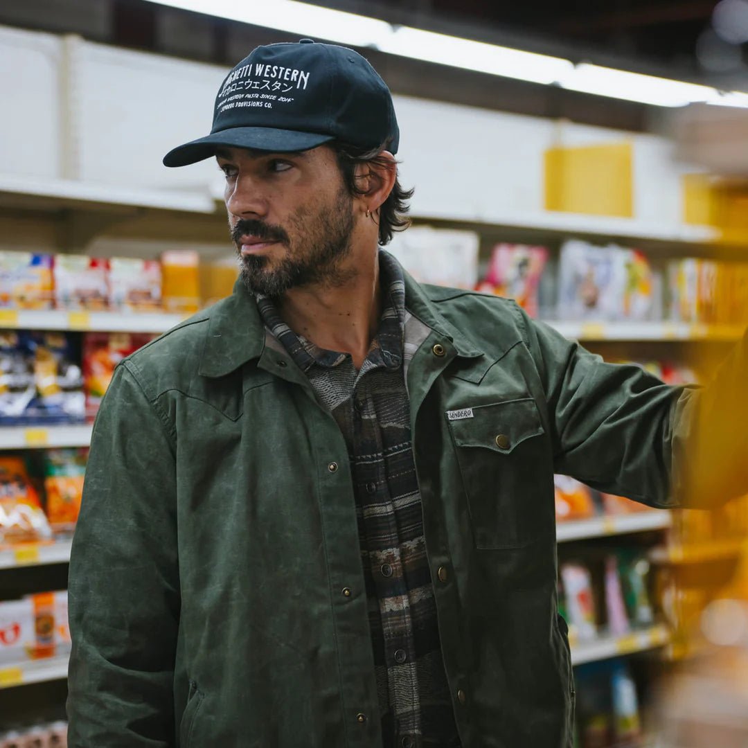 Model wearing Sendero Spaghetti Western Hat with leather strapback, pop-up mesh, and western-inspired embroidered design.